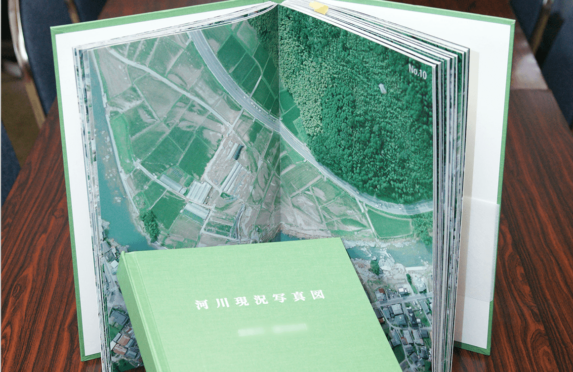 河川の状況を空撮。数十キロの地形をデータ化。それらをプリントし、製本加工を手作業したもの。